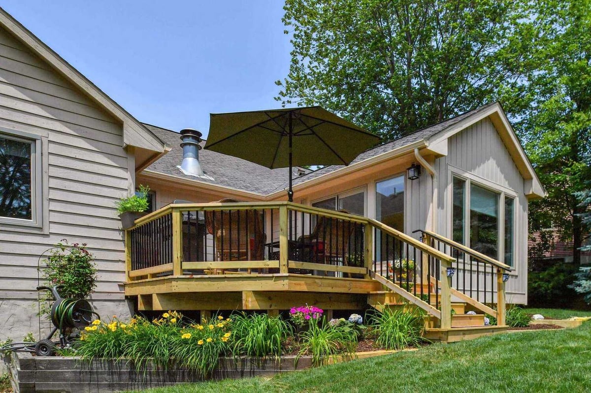 elevated backyard deck addition with railing and seating area by Odd Fellows Contracting in Okemos, MI
