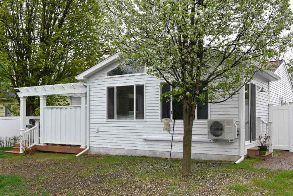 Rear home addition with large windows and patio door installed by Lansing MI remodeling contractor