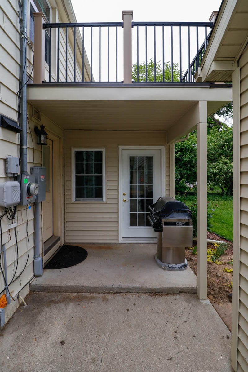 Covered patio entry beneath deck by Odd Fellows Contracting in Orchard-Street, MI as part of sunroom project.