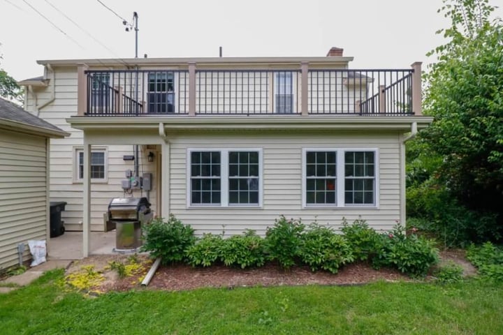 Exterior sunroom addition in East Lansing by Odd Fellows Contracting with a second-story deck and enclosed lower level
