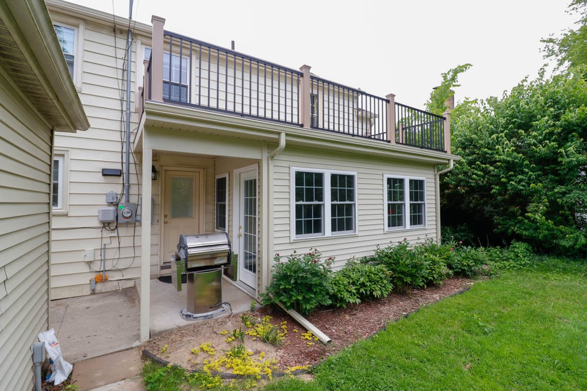 Rear exterior sunroom addition by Odd Fellows Contracting in Orchard-Street, MI with second-story deck above.