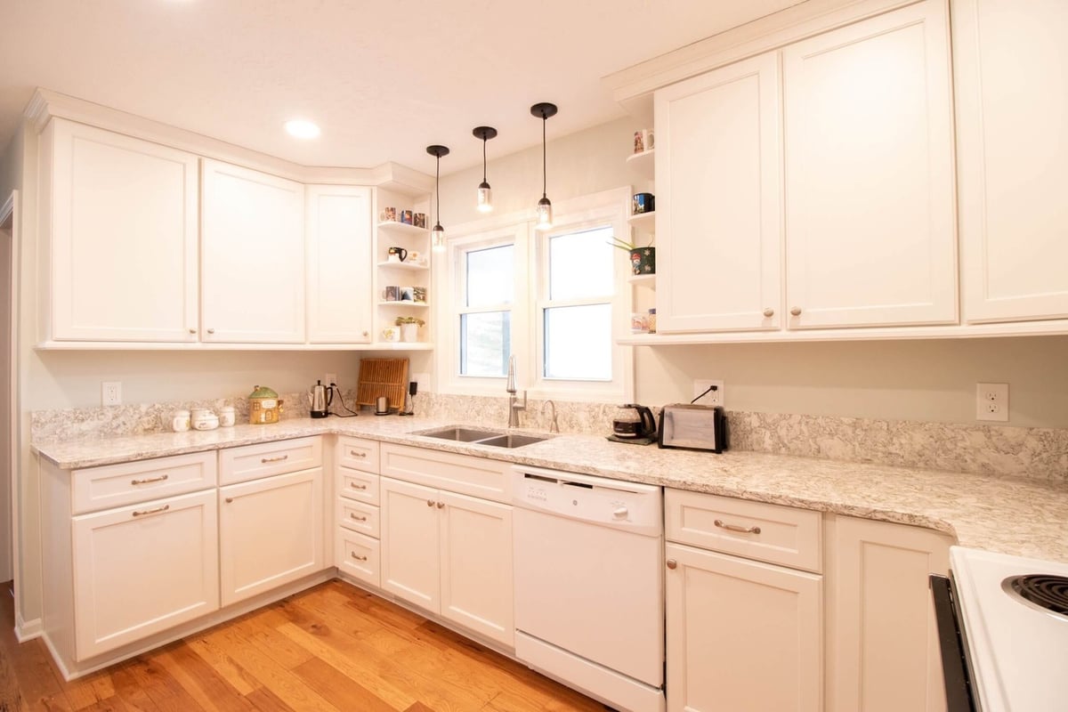 remodeled kitchen with white cabinets and double sink under window by Odd Fellows Contracting in Onondaga, MI