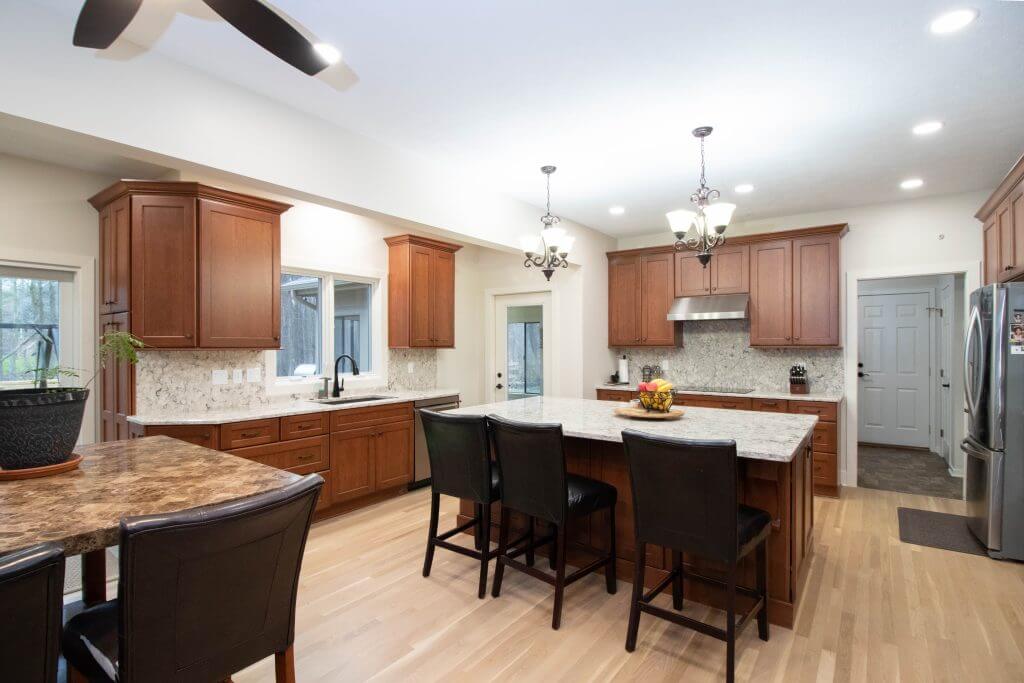 remodeled kitchen with large island and custom wood cabinets by Odd Fellows Contracting in Okemos, MI