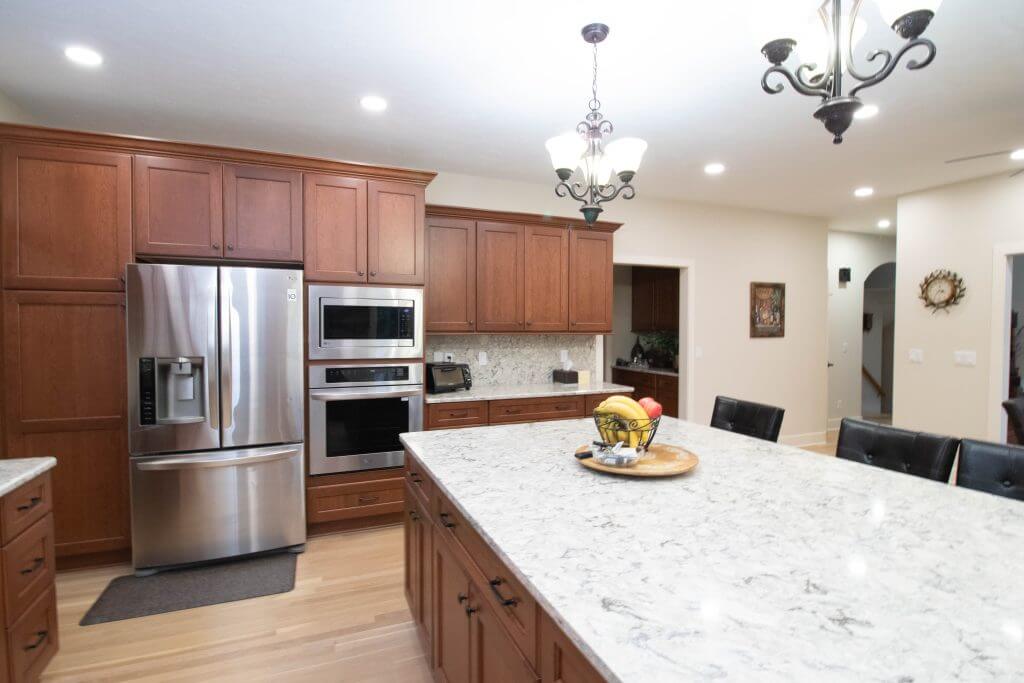 updated kitchen with island and modern appliances by Odd Fellows Contracting in Okemos, MI