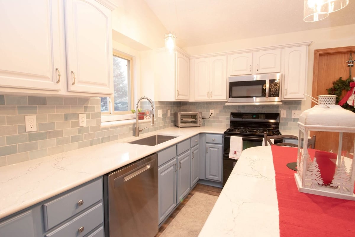 kitchen renovation featuring quartz countertops and subway tile backsplash by Odd Fellows Contracting in Charlotte, MI