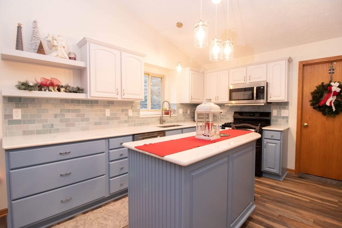 remodeled kitchen with blue island and pendant lighting by Odd Fellows Contracting in Charlotte, MI