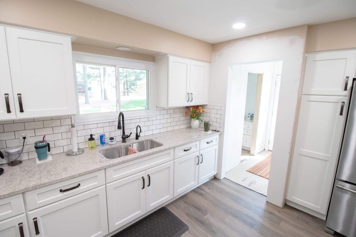 Bright kitchen remodel featuring white cabinets and farmhouse style sink area by Odd Fellows Contracting in Eaton Rapids, MI