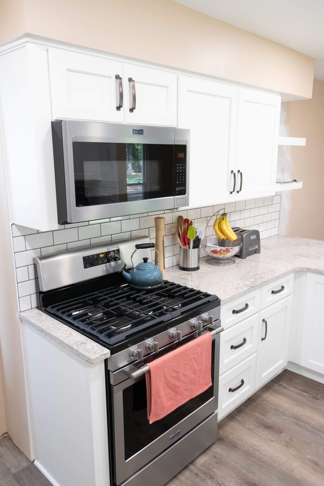 Kitchen remodel with white shaker cabinets and stainless steel gas range by Odd Fellows Contracting in Eaton Rapids, MI
