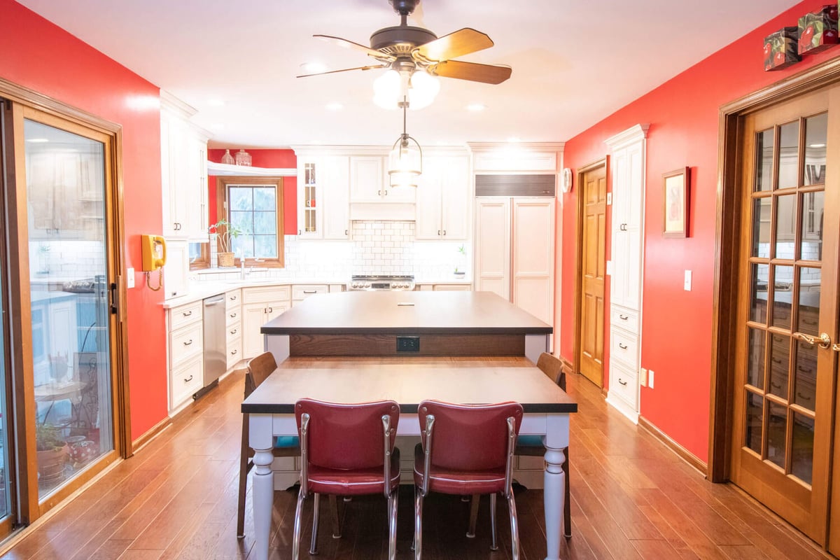 kitchen renovation featuring central island with seating and bright white cabinetry by Odd Fellows Contracting in Okemos, MI