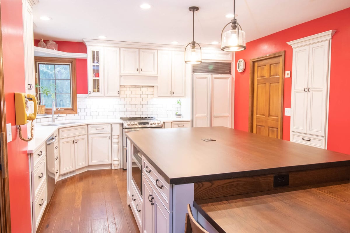 remodeled kitchen island with seating and surrounding white cabinetry by Odd Fellows Contracting in Okemos, MI