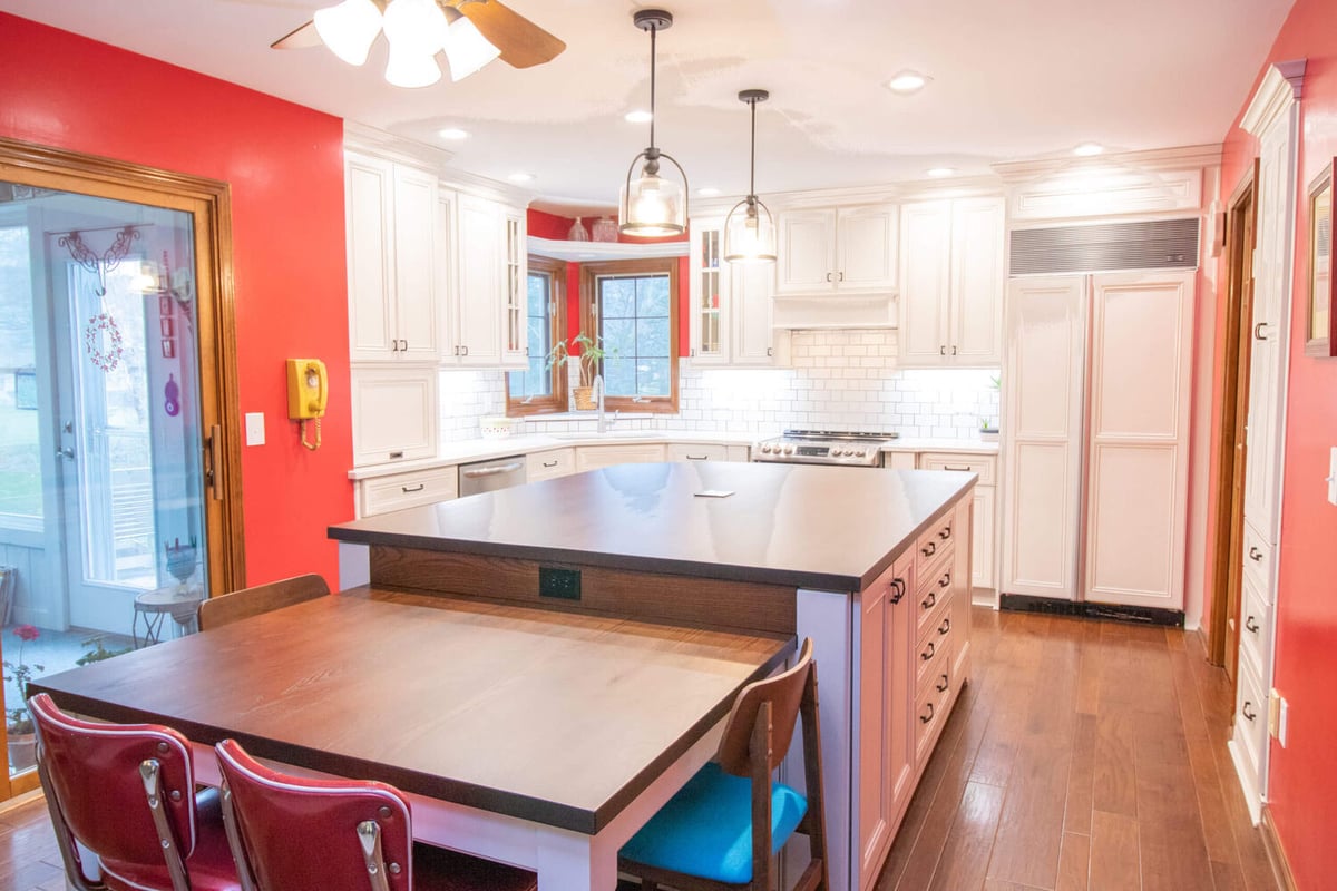 remodeled kitchen with large island seating, white cabinets, and subway tile backsplash by Odd Fellows Contracting in Okemos, MI