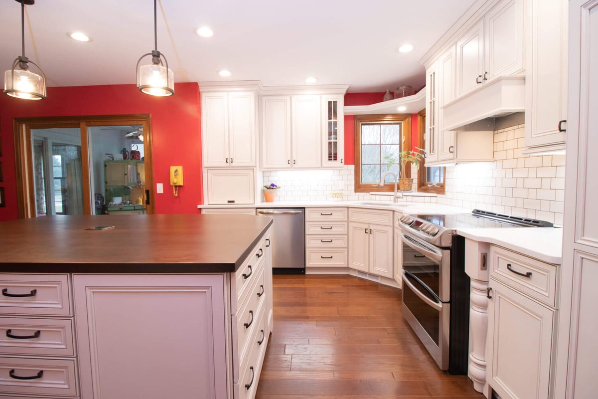 remodeled kitchen with large island, white cabinets, and subway tile backsplash by Odd Fellows Contracting in Okemos, MI