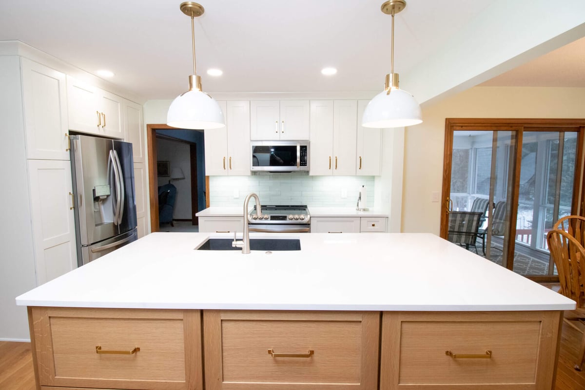 kitchen remodel with spacious island, quartz countertops, and stainless steel refrigerator by Odd Fellows Contracting in Okemos, MI