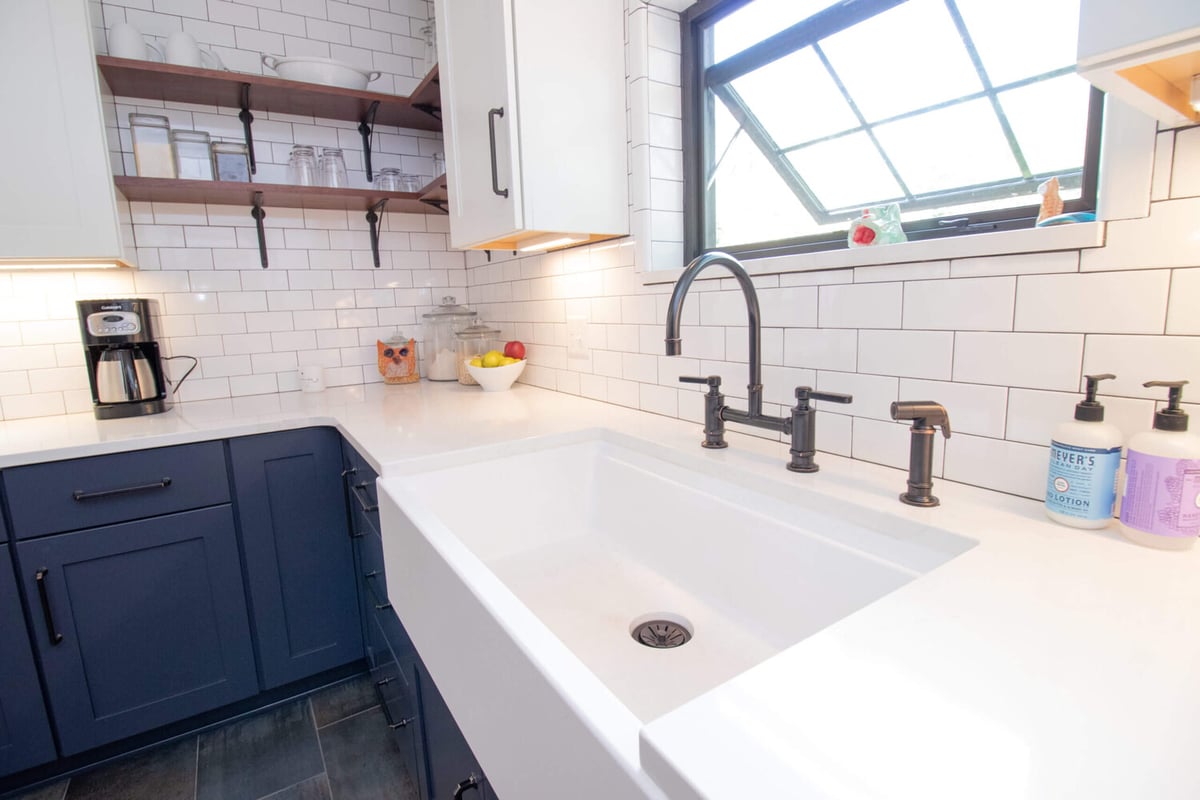 custom kitchen remodel featuring farmhouse sink and navy cabinetry by Odd Fellows Contracting in East Lansing MI