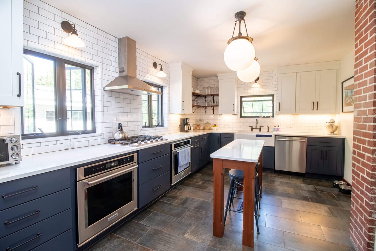 modern kitchen remodel with navy cabinets and white countertops by Odd Fellows Contracting in East Lansing MI
