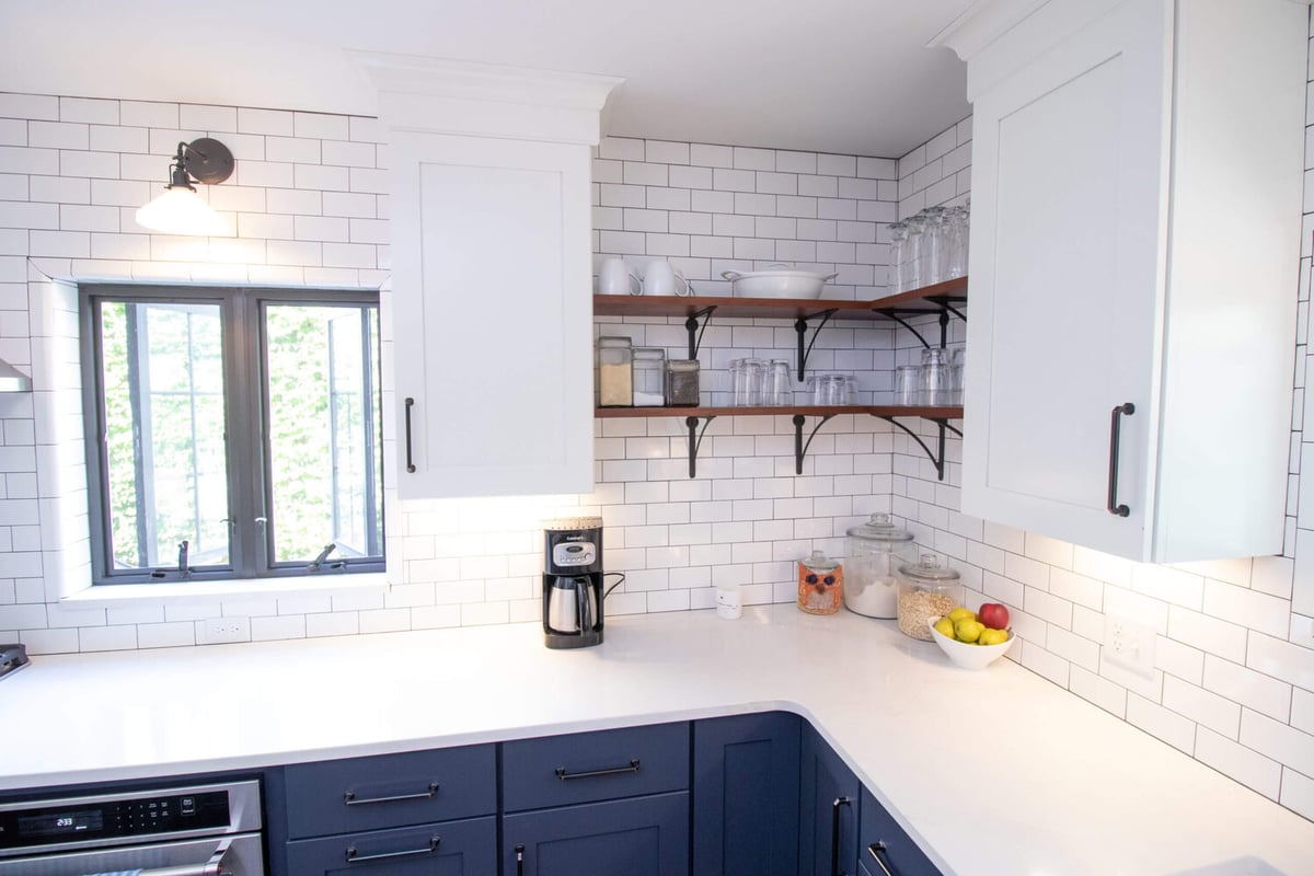 renovated kitchen corner with quartz countertops and navy cabinets by Odd Fellows Contracting East Lansing MI