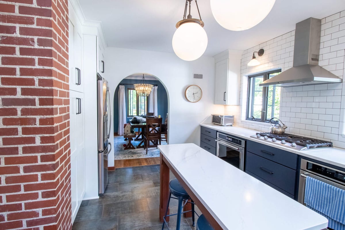 renovated kitchen featuring navy cabinetry and quartz island by Odd Fellows Contracting East Lansing MI