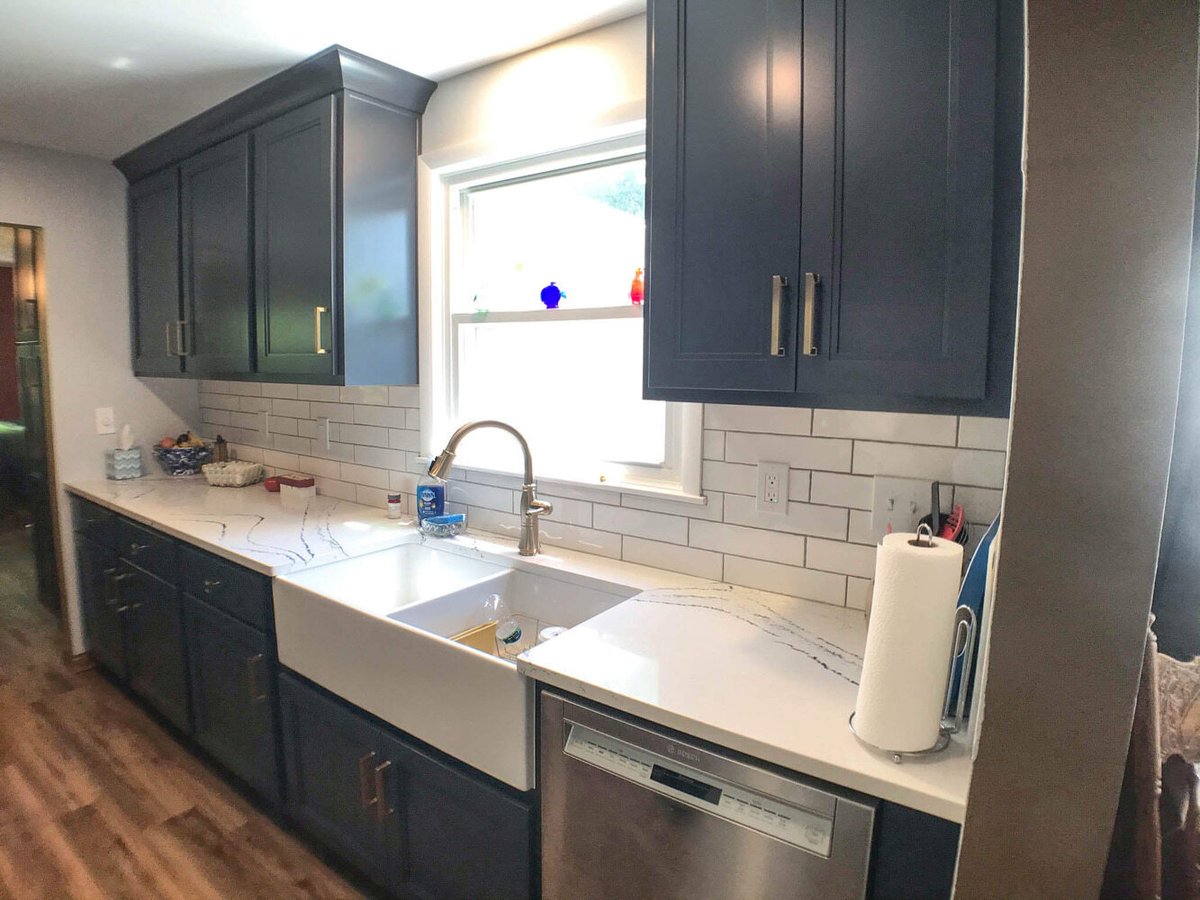 kitchen remodel with dark blue shaker cabinets, quartz countertops, farmhouse sink, and subway tile backsplash by Odd Fellows Contracting in Williamston, MI.jpg.jpg