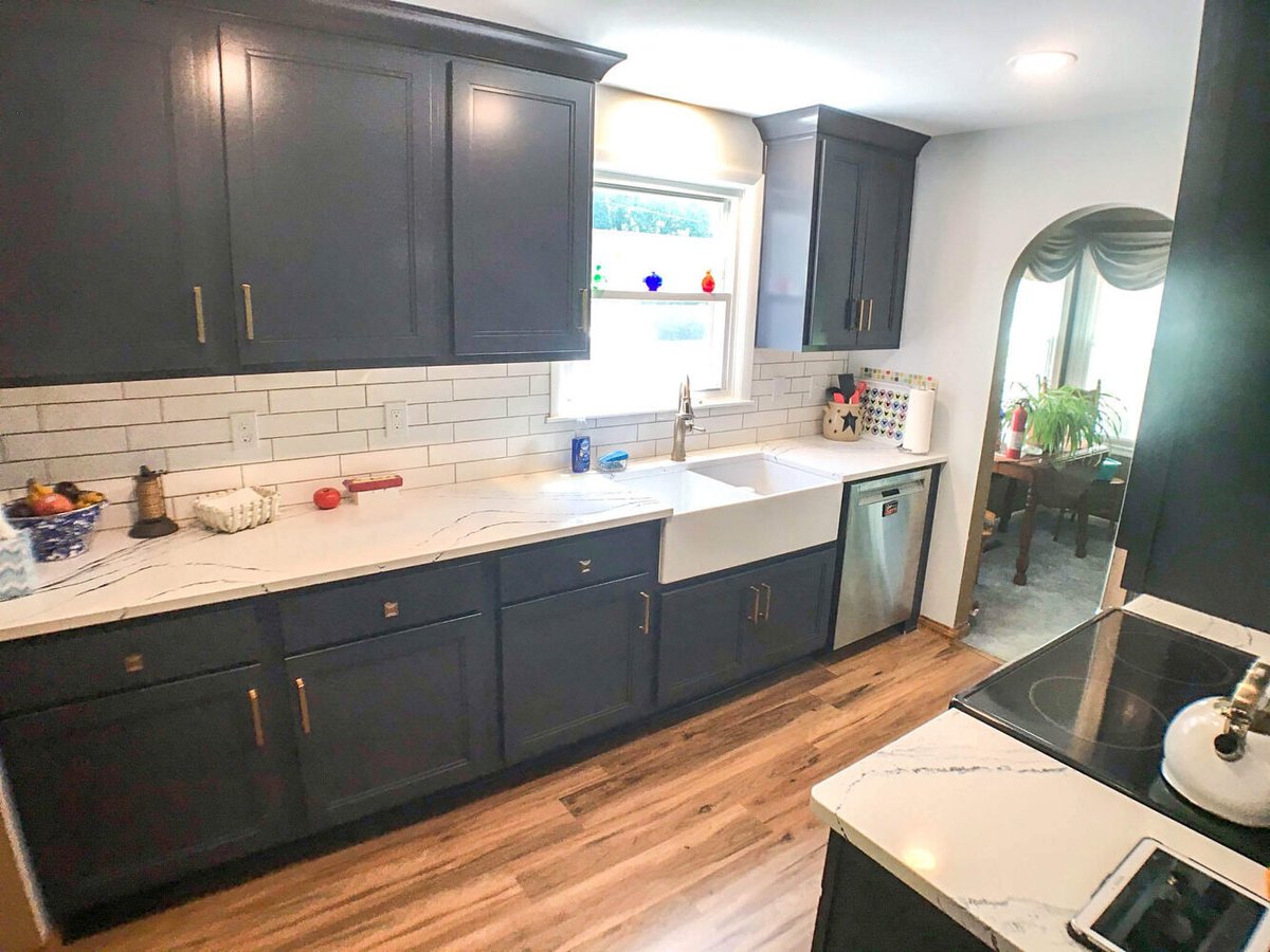 modern kitchen remodel with dark blue cabinets, quartz countertops, farmhouse sink, and subway tile backsplash by Odd Fellows Contracting in Williamston, MI.jpg.jpg