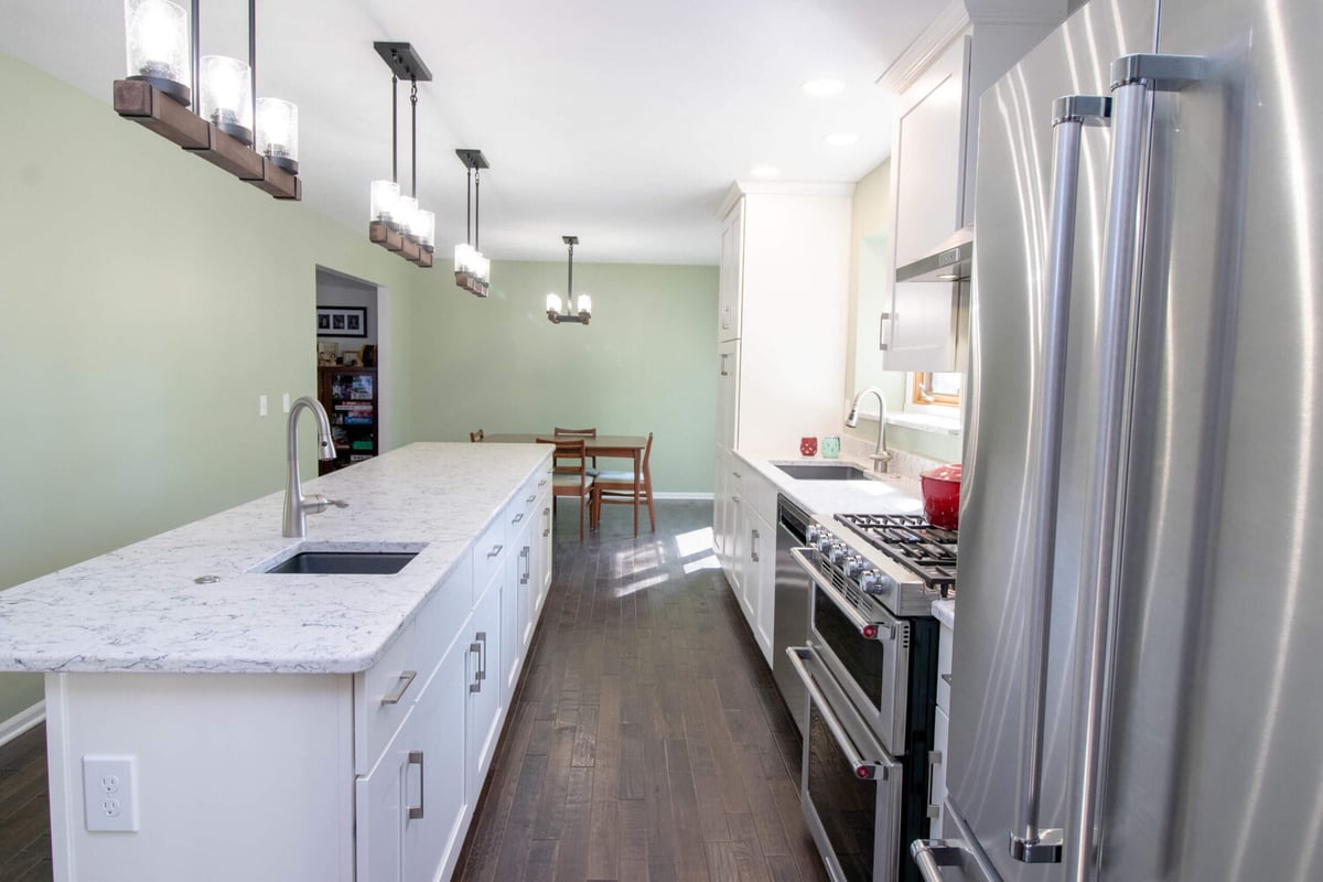 renovated kitchen by Odd Fellows Contracting in Haslett MI featuring quartz island and modern lighting
