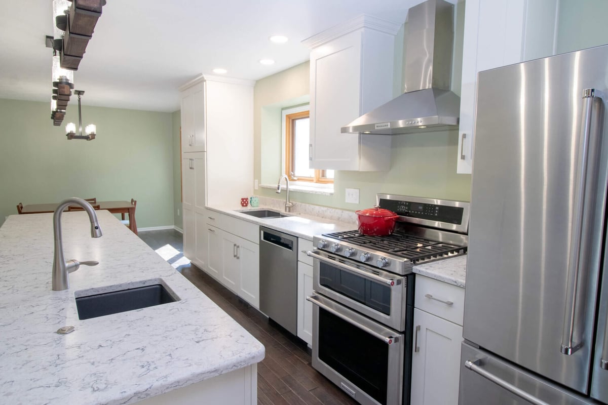 updated kitchen by Odd Fellows Contracting in Haslett MI with island seating and pendant lighting