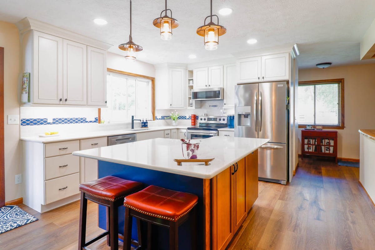 Kitchen renovation by Odd Fellows Contracting in Williamston, MI showcasing quartz countertops and blue accent tile.