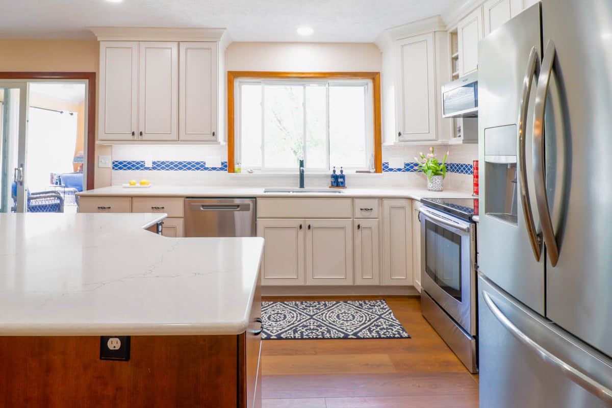 Renovated kitchen workspace in Williamston, MI by Odd Fellows Contracting with new cabinetry and flooring.