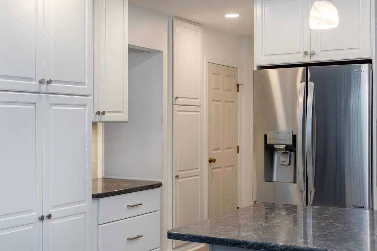 Custom kitchen cabinetry and refrigerator wall from remodel by Odd Fellows Contracting in Haslett, MI