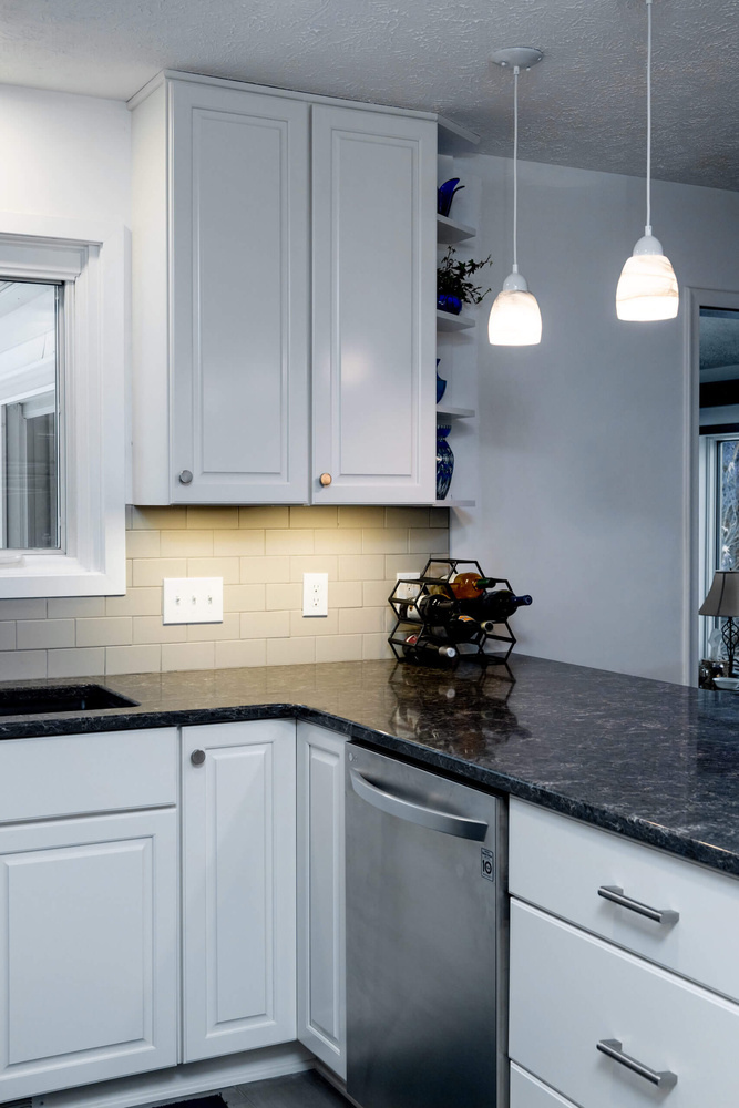 Modern kitchen remodel with white cabinets, stainless appliances, and peninsula by Odd Fellows Contracting in Haslett, MI