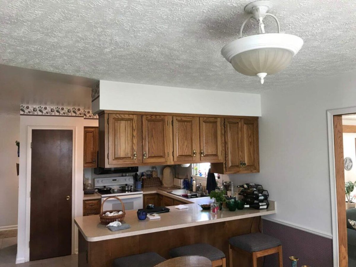 Original kitchen with wood cabinets and peninsula before remodel by Odd Fellows Contracting in Haslett, MI