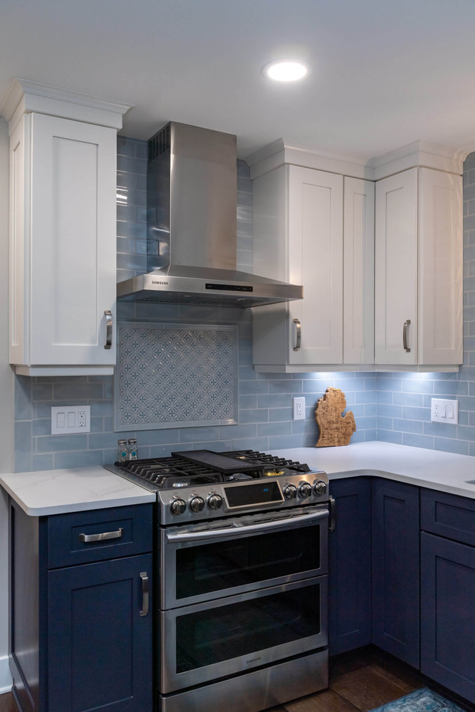 Modern kitchen remodel with custom range hood and patterned backsplash by Odd Fellows Contracting in Okemos, MI