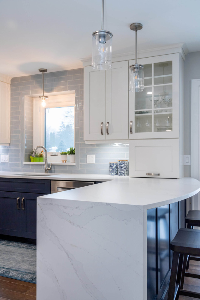 Modern kitchen renovation with quartz countertops and tile backsplash by Odd Fellows Contracting in Okemos, MI