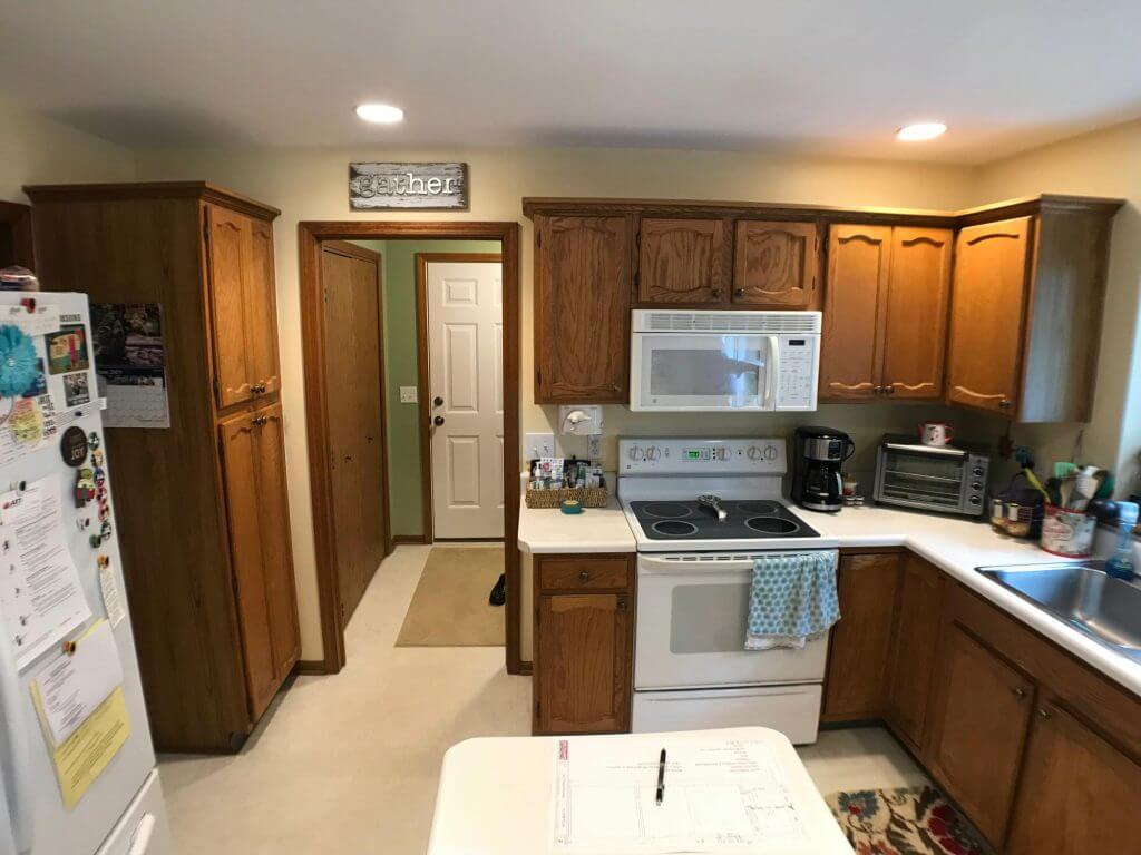 Original kitchen layout with wood cabinetry before renovation by Odd Fellows Contracting in Okemos, MI
