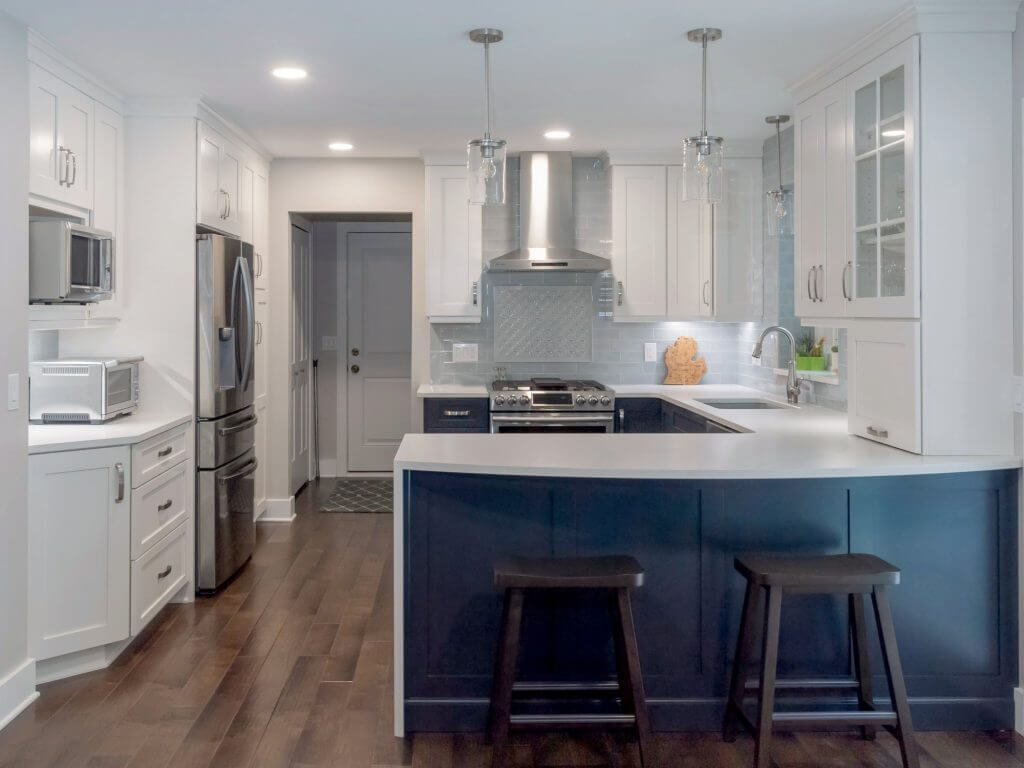 Updated kitchen and dining remodel featuring custom cabinetry and hardwood floors by Odd Fellows Contracting in Okemos, MI