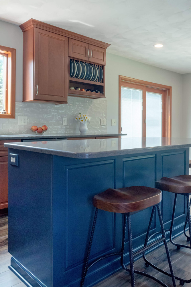 remodeled kitchen island with bar stools and stone countertop by Odd Fellows Contracting in Grand Ledge, MI