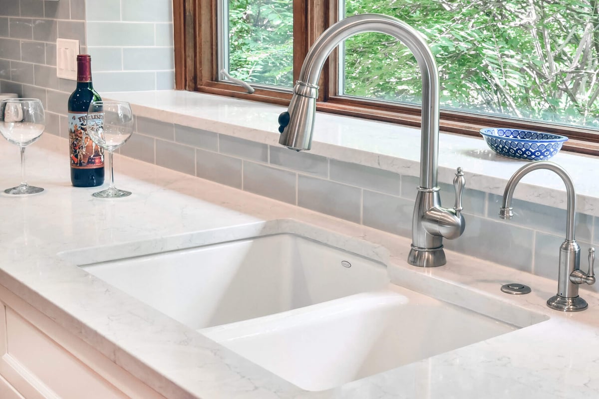 farmhouse style kitchen sink with window view in remodel by Odd Fellows Contracting in Okemos, MI