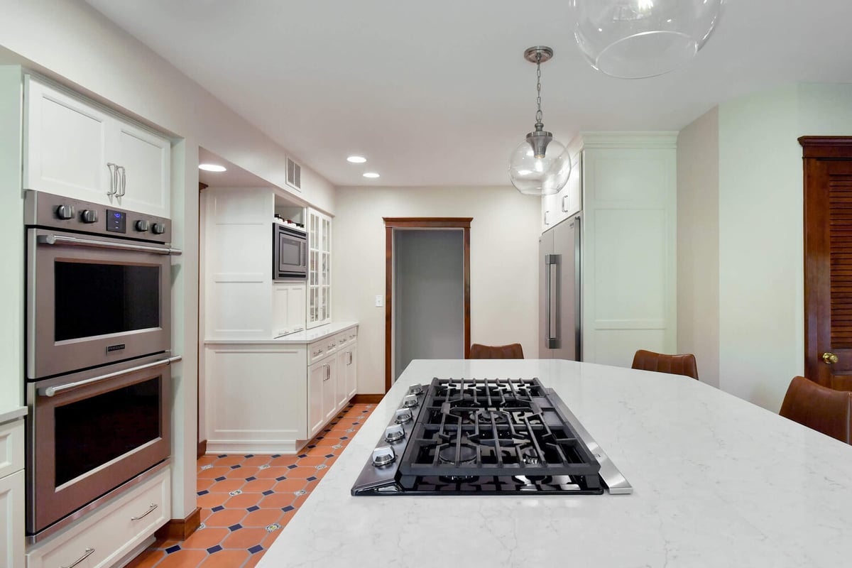 modern kitchen renovation with quartz island and stainless appliances by Odd Fellows Contracting in Okemos, MI
