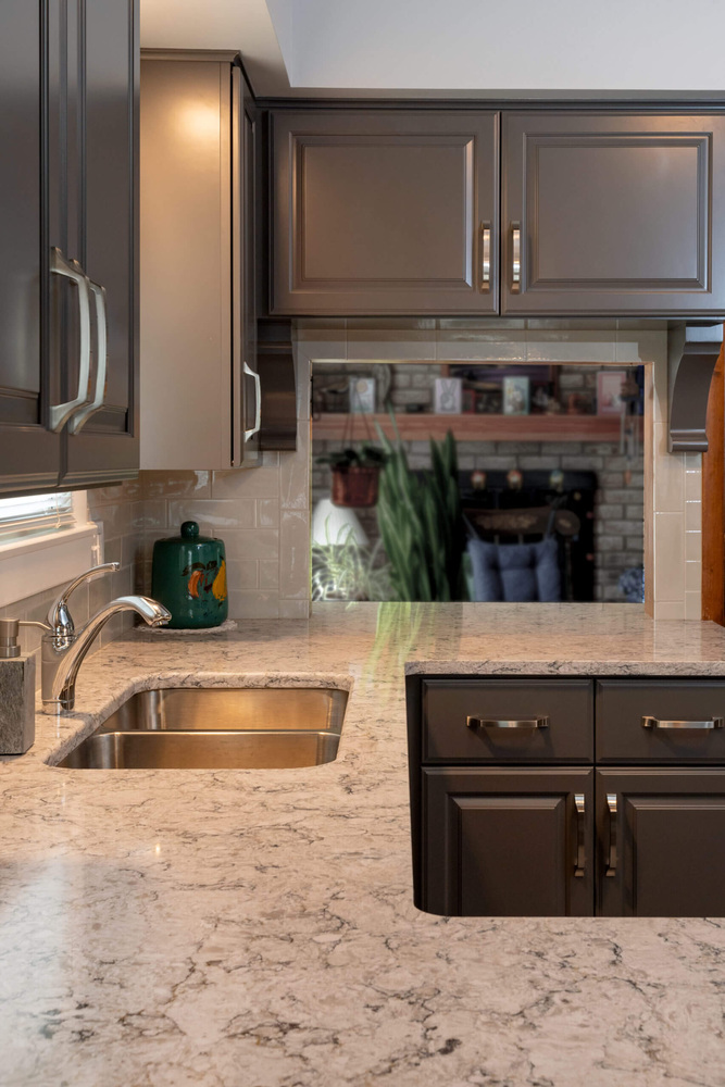 remodeled kitchen sink and counter area with gray cabinets by Odd Fellows Contracting in Lansing, MI