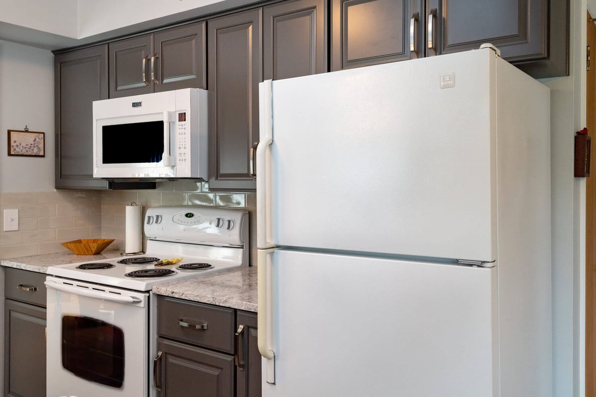 updated kitchen appliance wall with gray cabinets and quartz counters by Odd Fellows Contracting in Lansing, MI