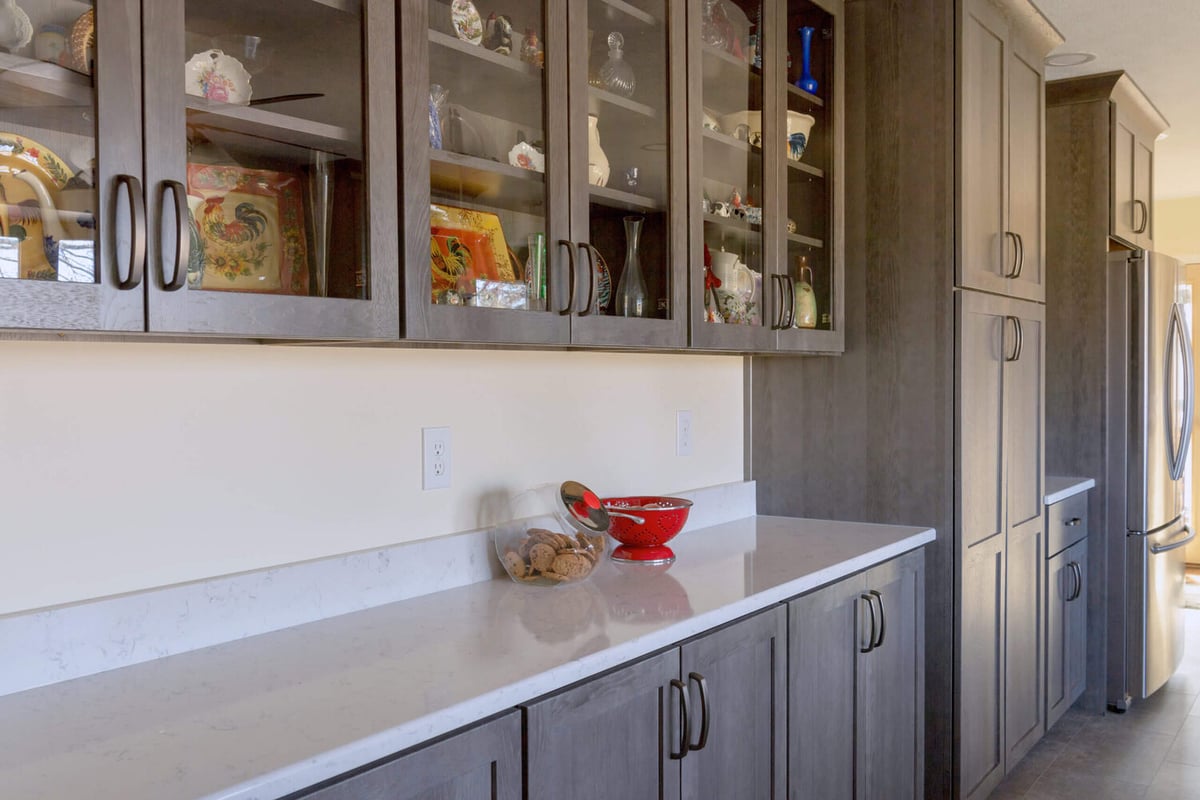 custom kitchen cabinetry with glass doors and quartz counters by Odd Fellows Contracting in Onondaga, MI