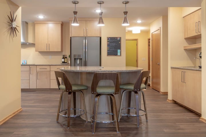 Large kitchen island with seating and pendant lighting in remodeled East Lansing MI kitchen by Odd Fellows Contracting