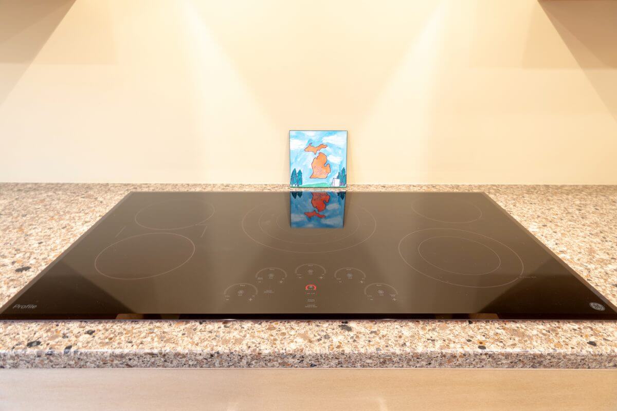 Modern electric cooktop installed in granite countertop during kitchen remodel by Odd Fellows Contracting in East Lansing MI