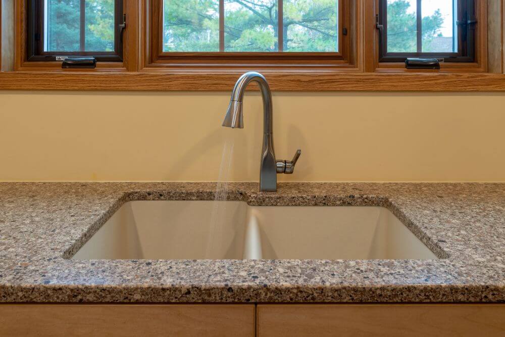 Undermount kitchen sink with modern faucet and granite countertops in East Lansing MI kitchen remodel by Odd Fellows Contracting