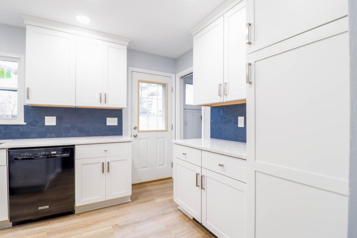 completed kitchen remodel by Odd Fellows Contracting in Cumberland Lansing, MI with white shaker cabinets and blue hex tile backsplash