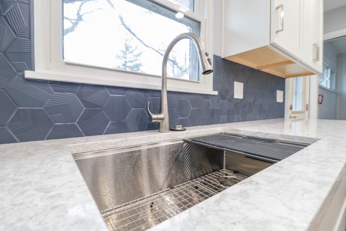 kitchen remodel in Cumberland Lansing, MI by Odd Fellows Contracting featuring blue tile backsplash and stainless sink
