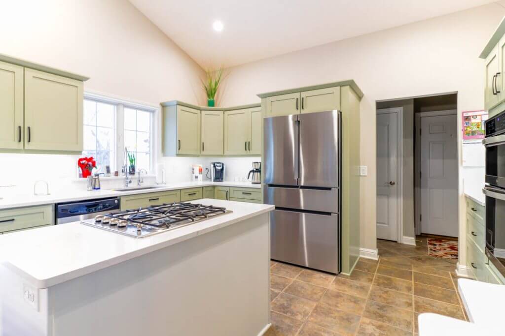 bright kitchen remodel by Odd Fellows Contracting in Candlewood Estates, MI with white quartz island and gas cooktop