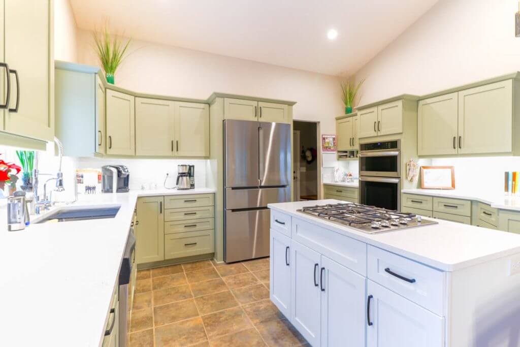 completed kitchen remodel by Odd Fellows Contracting in Candlewood Estates, MI with sage green shaker cabinets and white island