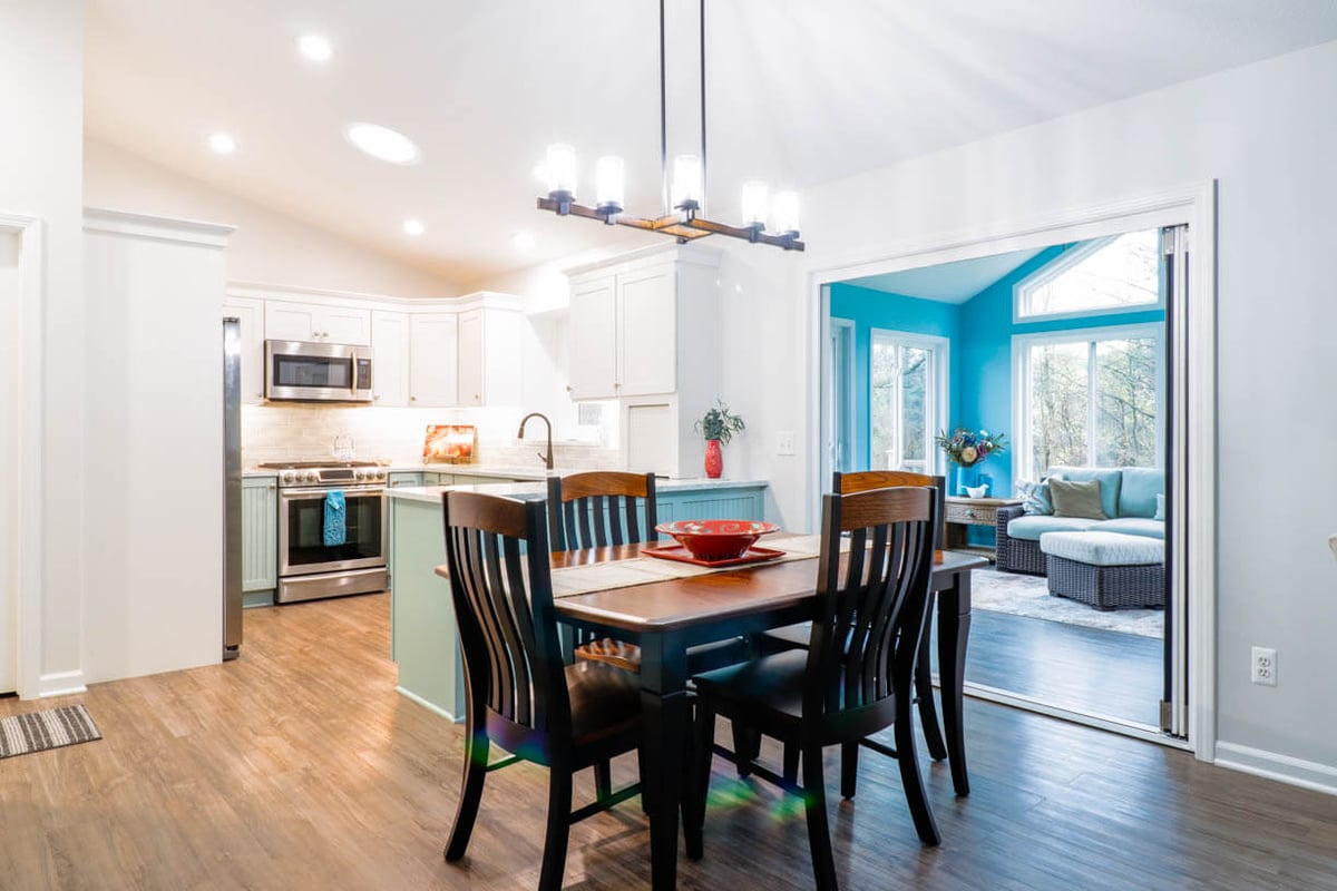 dining area view of kitchen remodel by Odd Fellows Contracting in Williamston, MI with open layout and updated flooring
