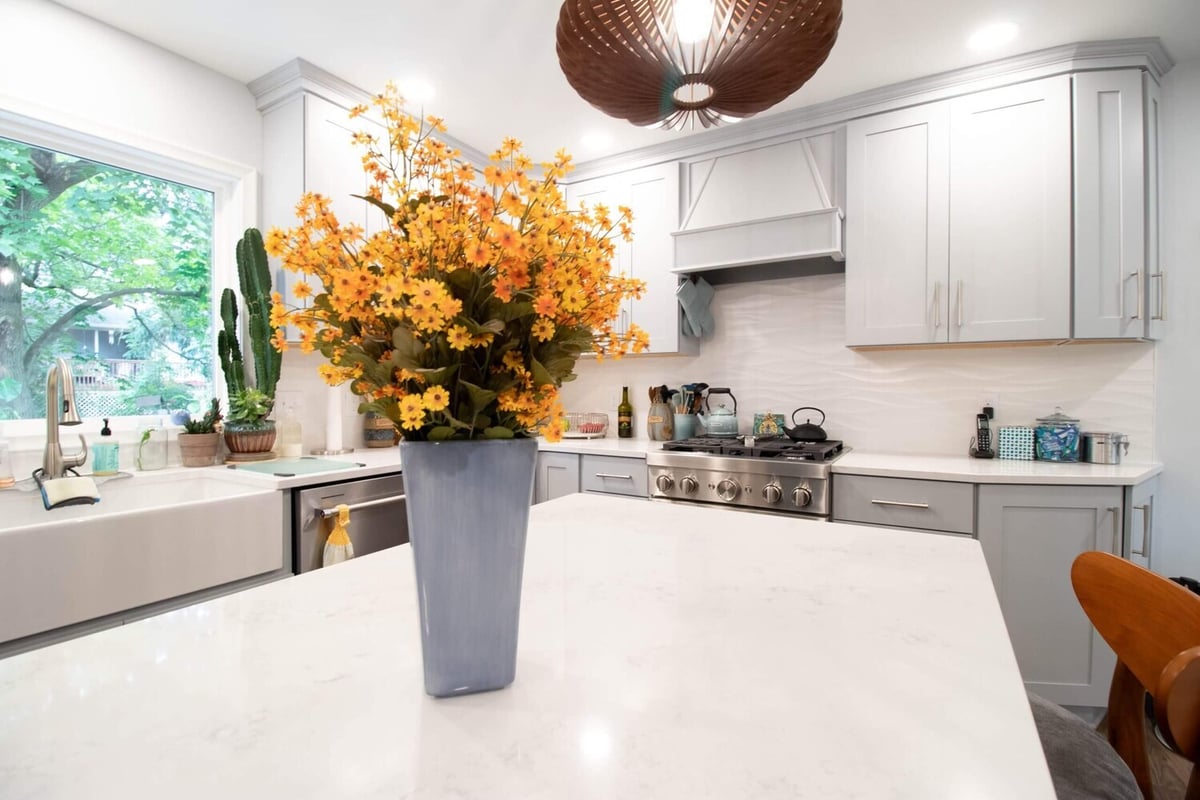 quartz kitchen island with pendant lighting in Okemos, MI custom home by Odd Fellows Contracting
