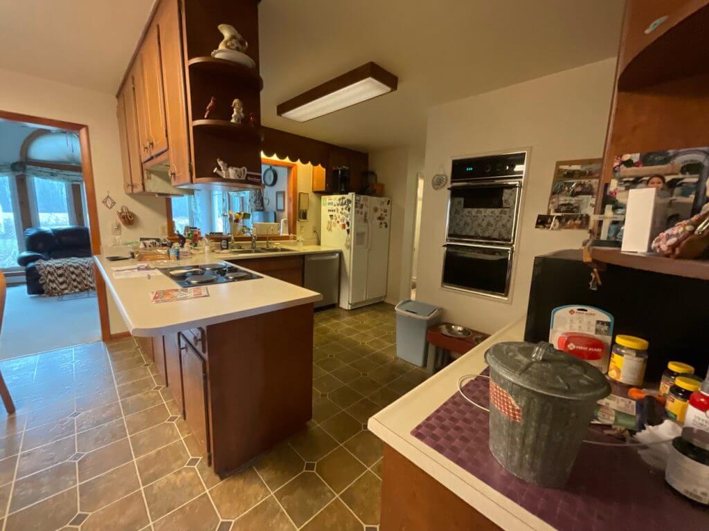 existing kitchen before remodel by Odd Fellows Contracting in Owosso, MI with dated wood cabinets